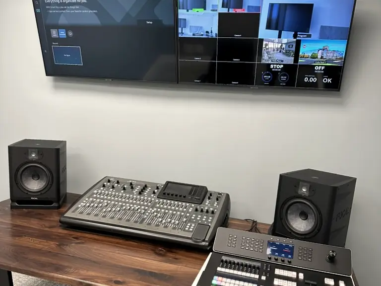 Finished control desk with audio mixer, video switcher and multiview monitors in a custom studio build